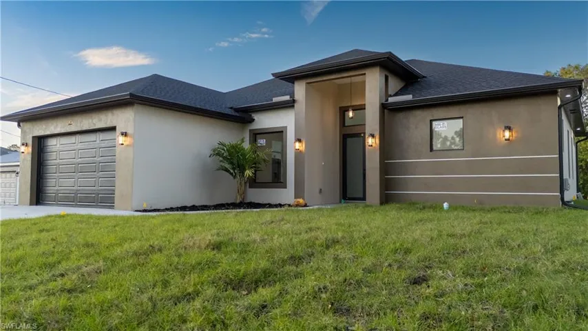View of front of home featuring an attached garage, stucco siding, and a front lawn
