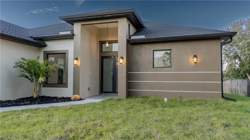 Property entrance featuring a shingled roof and stucco siding