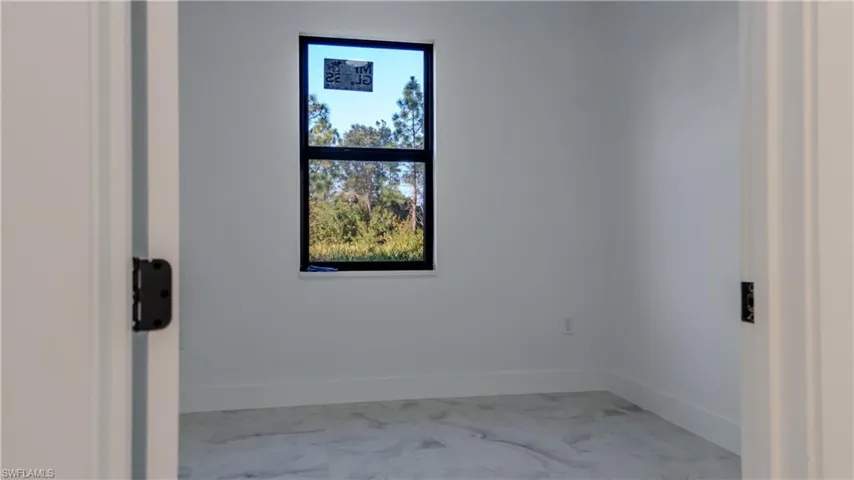 Spare room featuring baseboards and light marble finish flooring