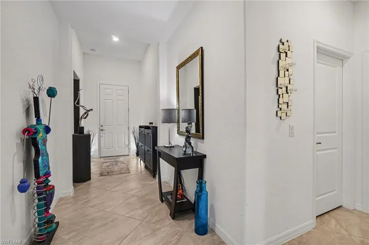 Corridor with light tile patterned floors and baseboards