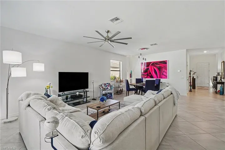 Living room featuring a ceiling fan and light tile patterned floors