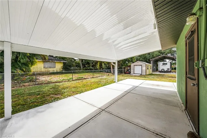 Fenced backyard featuring a patio area and a storage unit