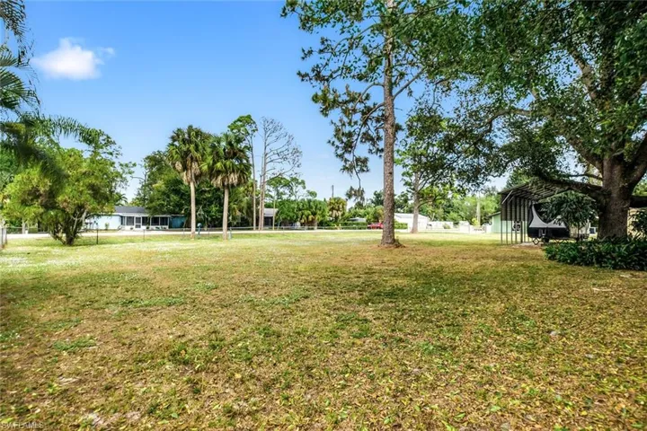 View of green lawn with a detached carport
