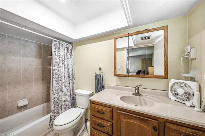 Kitchen featuring white appliances, brown cabinets, light wood finished floors, recessed lighting, and washing machine and clothes dryer