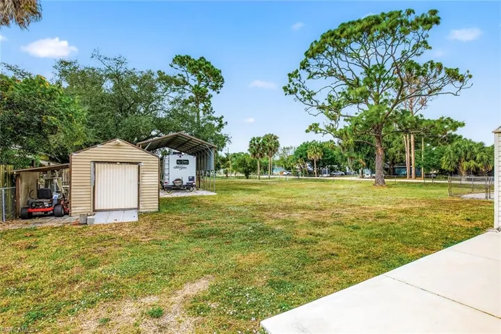 View of yard featuring a shed and a carport