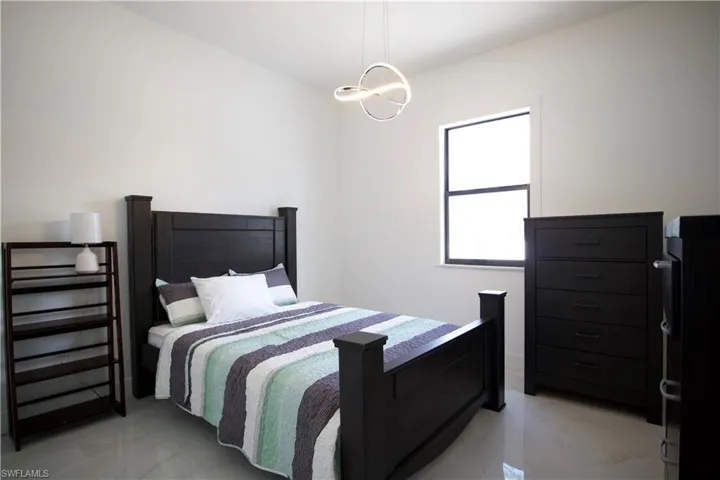 Bedroom with a chandelier and light tile floors
