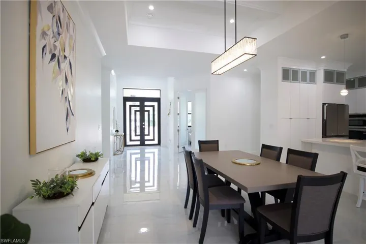 Tiled dining space featuring a tray ceiling