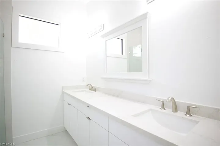Bathroom featuring tile floors and dual vanity