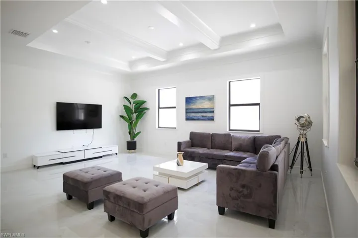 Tiled living room with beam ceiling and a tray ceiling