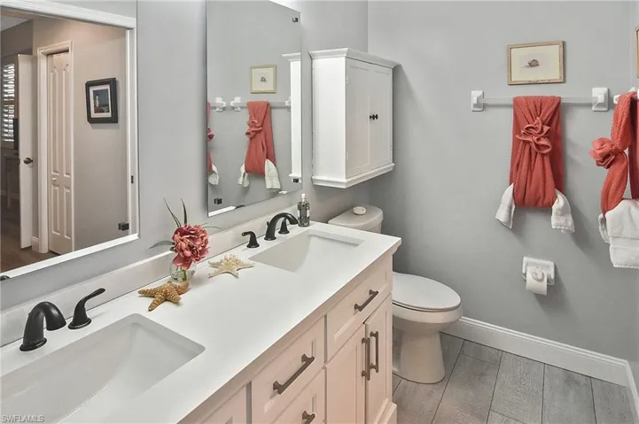 Bathroom featuring double vanity and baseboards