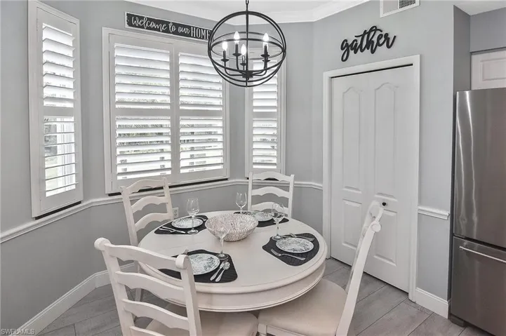 Dining space featuring a chandelier, ornamental molding, and light wood-type flooring