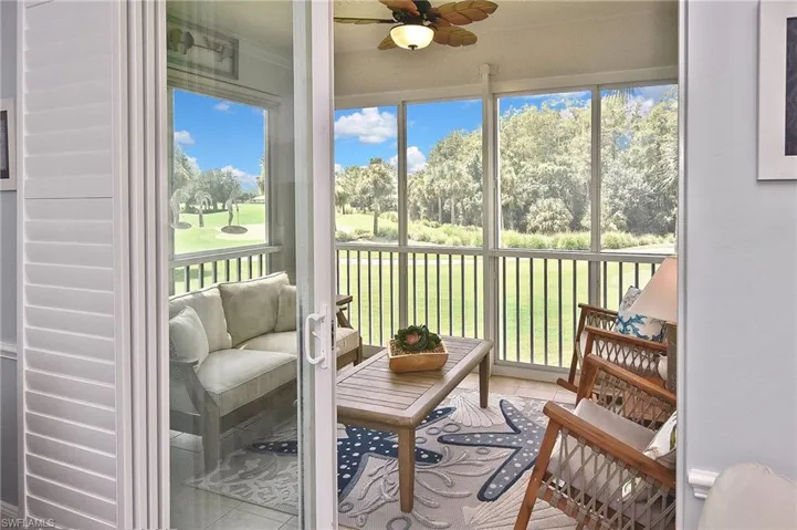 Sunroom featuring a ceiling fan, view of scattered trees, and view of golf course