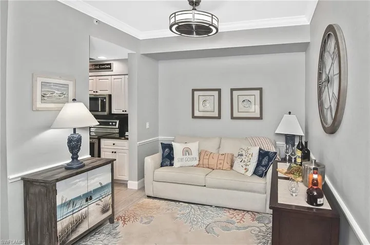 Living area featuring light wood-type flooring and ornamental molding