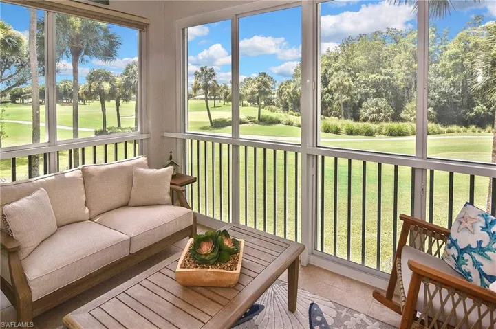 Sunroom featuring view of golf course, outdoor lounge area, and view of wooded area