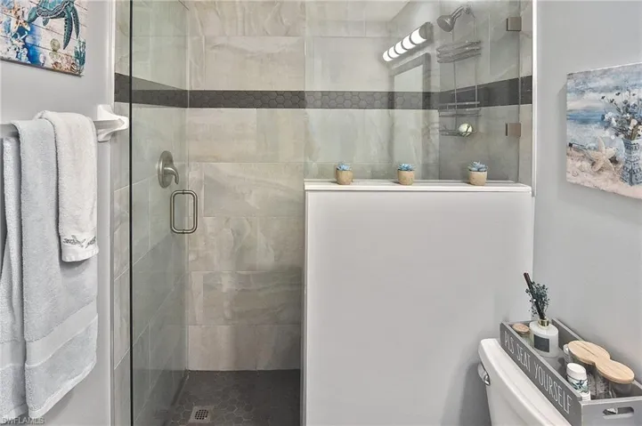 Bathroom featuring a shower stall and toilet