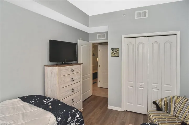 Bedroom with dark wood-style floors and a closet