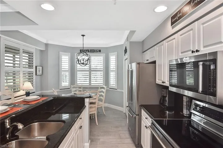 Kitchen with stainless steel appliances, light wood-style floors, recessed lighting, white cabinets, and crown molding