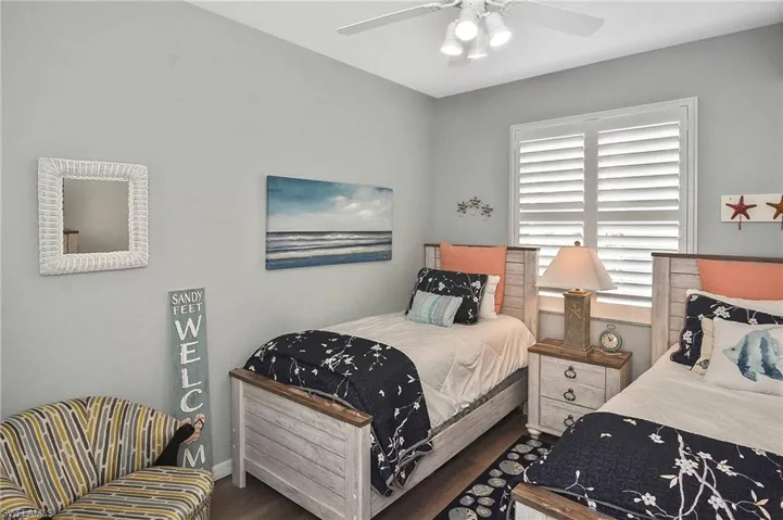 Bedroom with ceiling fan and dark wood-style flooring