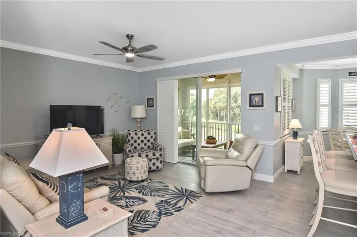 Living room with ceiling fan, ornamental molding, and wood finished floors