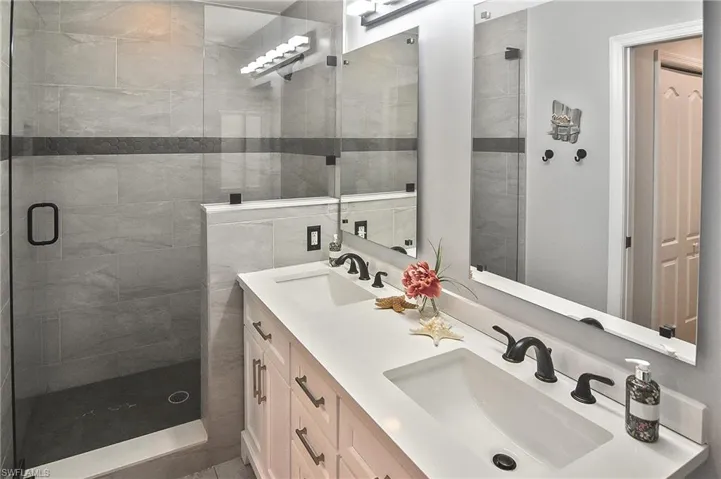Full bathroom with a shower stall and double vanity