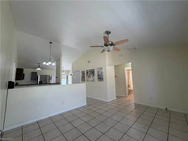 This property features a spacious living area with vaulted ceilings and tiled flooring, creating an open and airy atmosphere
