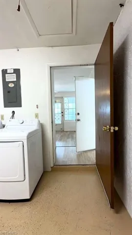 Utility area featuring a washer and dryer, an electrical panel, and a ceiling access panel
