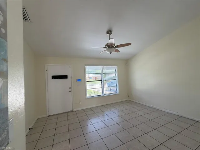 The living space features vaulted ceilings, tile flooring, and a ceiling fan with integrated lighting