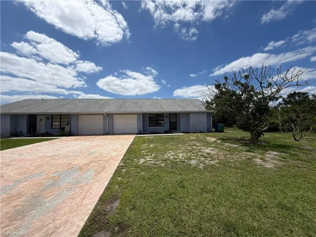 The property features a gray exterior, an attached garage, and a driveway