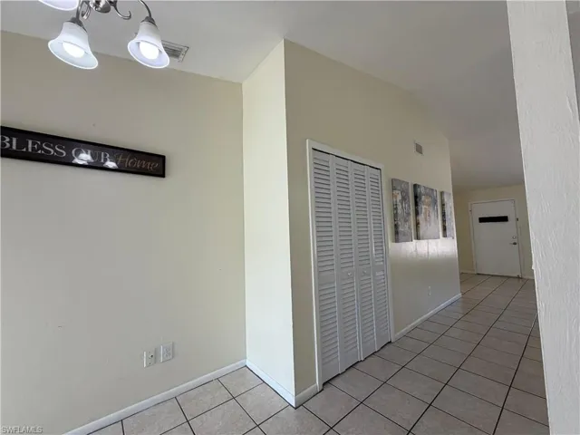 Entryway featuring tiled flooring, a light-colored wall finish, and a white louvered door