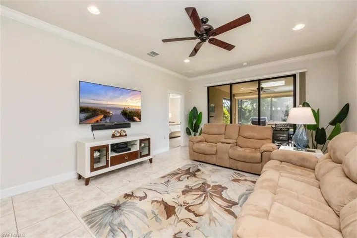 Living room with a ceiling fan, light tile patterned flooring, ornamental molding, and recessed lighting