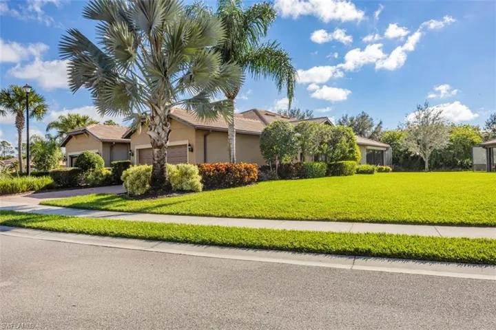 View of front of house with a front lawn, an attached garage, and stucco siding