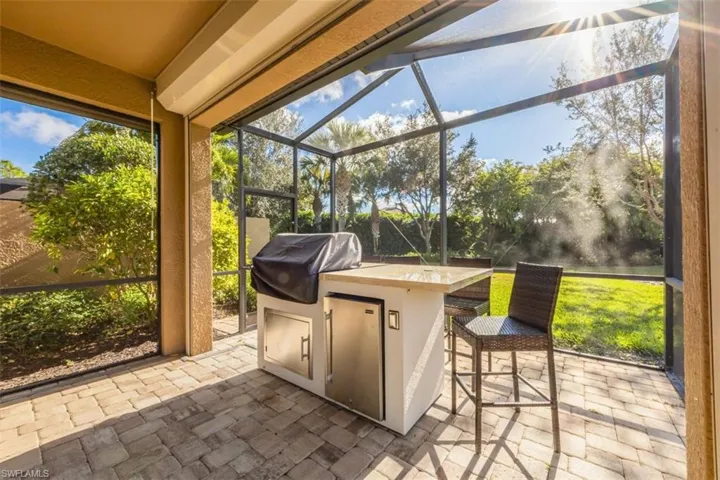 Sunroom with exterior kitchen and a patio area