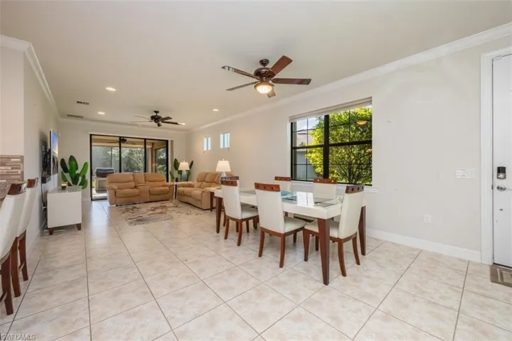 Dining room featuring ornamental molding, light tile patterned floors, ceiling fan, and recessed lighting