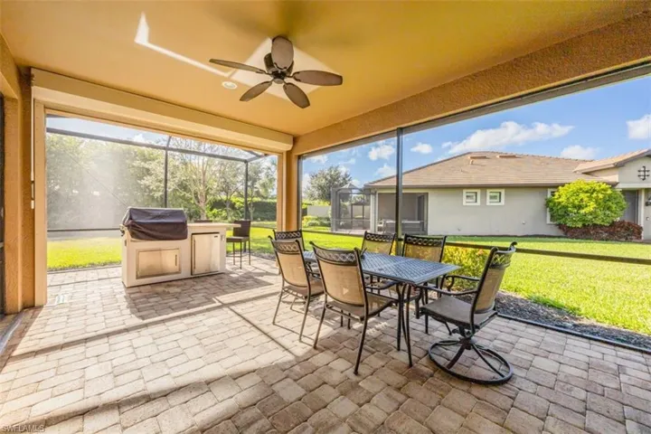 Sunroom / solarium with a ceiling fan, a patio area, and outdoor dining space