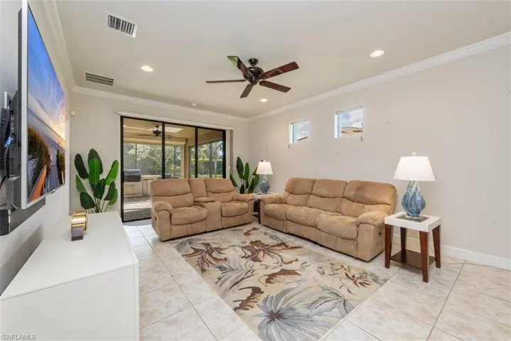 Living area featuring plenty of natural light, light tile patterned floors, ornamental molding, a ceiling fan, and recessed lighting