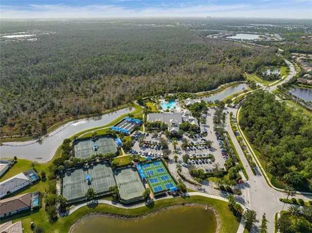 Aerial overview of property's location with a heavily wooded area and a nearby body of water