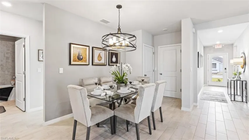 Model home. Dining area featuring light wood finished floors and suspended lighting
