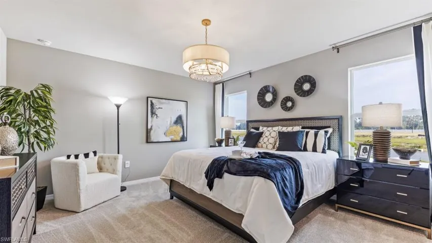 Model home. Carpeted bedroom featuring baseboards and suspended lighting