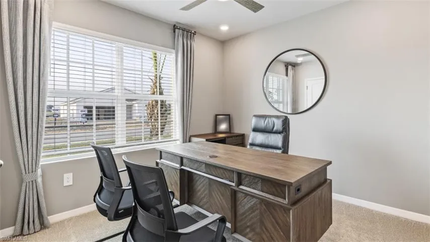 Model home. Office area featuring light colored carpet, plenty of natural light, a ceiling fan, and recessed lighting