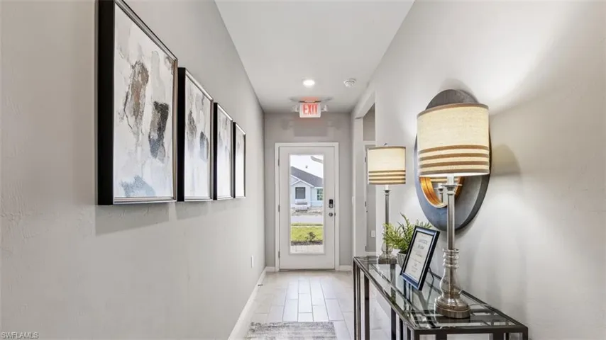 Model home. Doorway with wood finished floors and recessed lighting