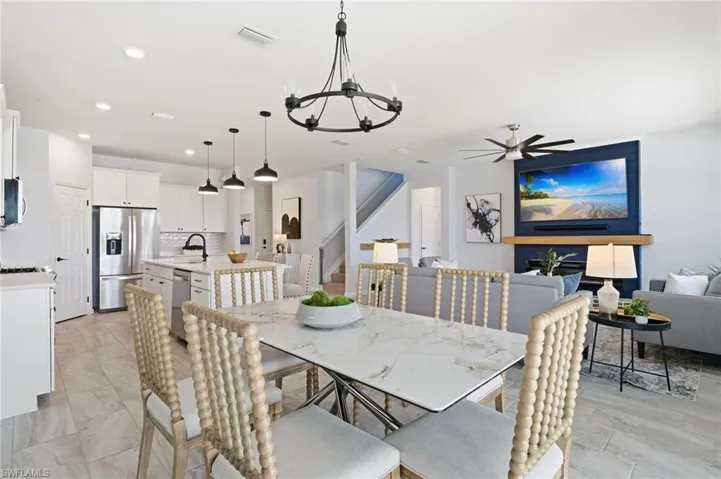 Dining room featuring a chandelier, ceiling fan, stairway, and recessed lighting