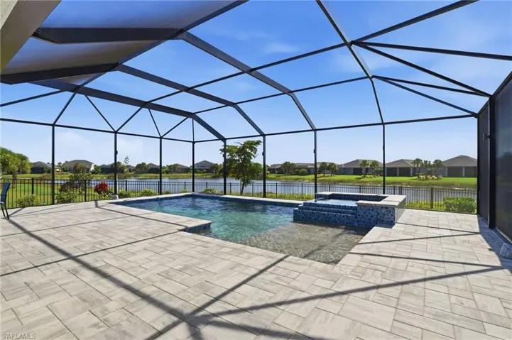 View of swimming pool with hot tub, a lanai, and a patio