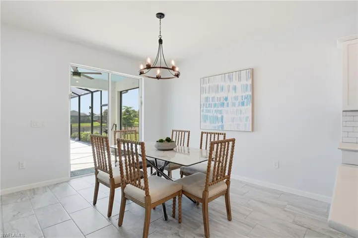 Dining space featuring a chandelier, ceiling fan, and light wood finished floors