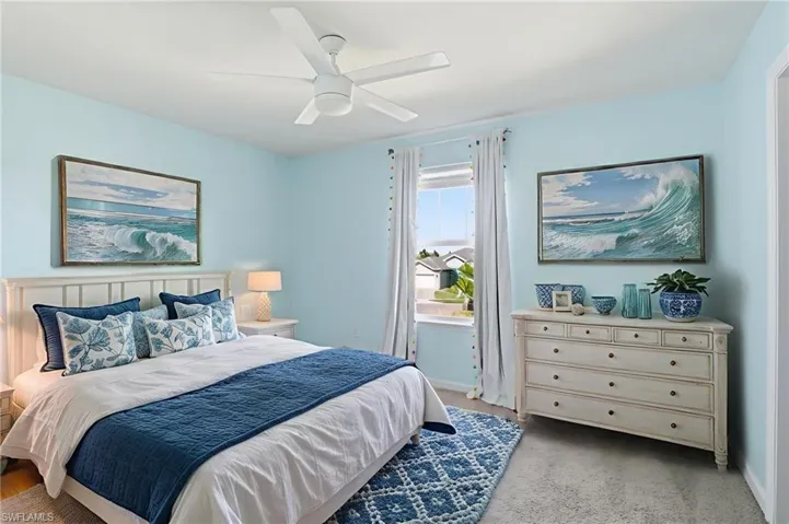 Bedroom with light colored carpet and a ceiling fan