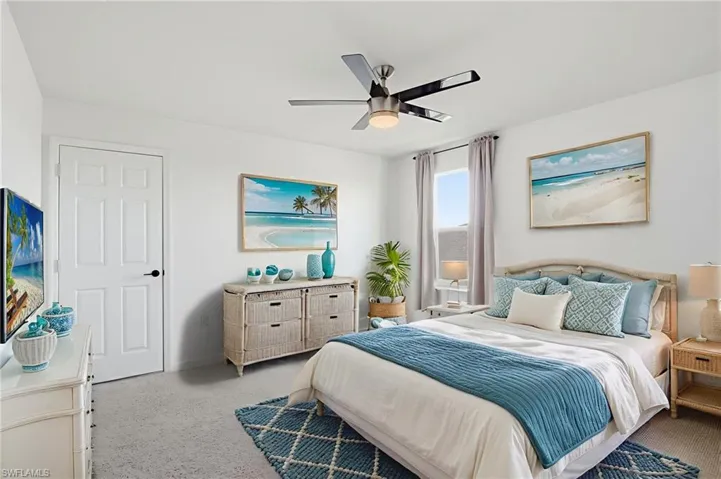 Carpeted bedroom with a ceiling fan