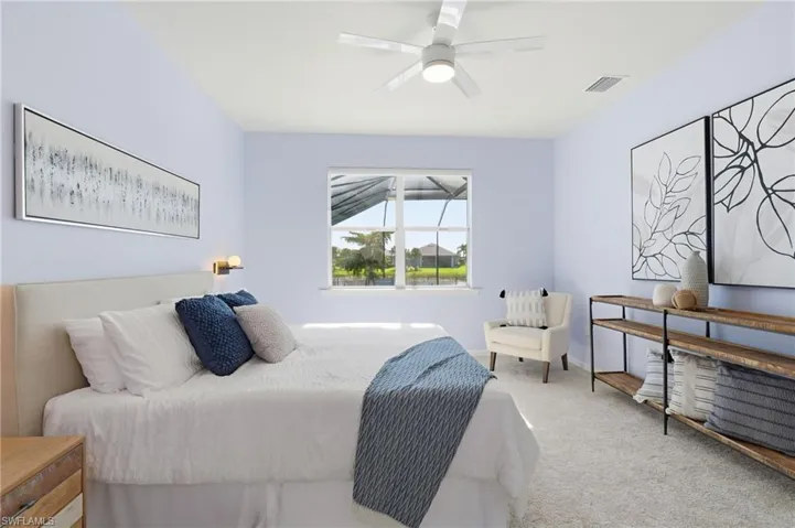 Carpeted bedroom with ceiling fan and baseboards