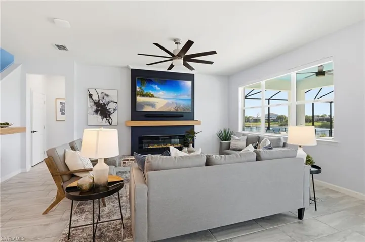 Living room with a glass covered fireplace and ceiling fan