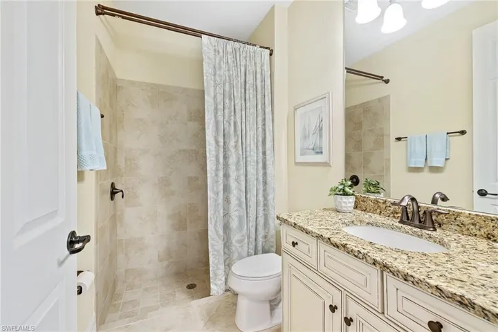 Bathroom featuring vanity, tile patterned flooring, and toilet