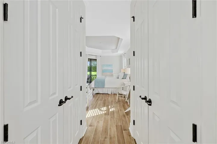 Hallway featuring light hardwood / wood-style floors and a raised ceiling