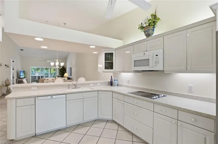 Kitchen featuring white cabinetry, light-toned countertops, a built-in microwave, and an electric cooktop